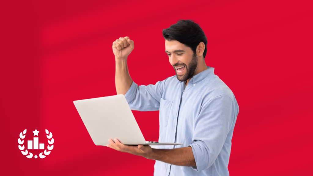 Erfolgreicher Mann mit Laptop jubelt vor rotem Hintergrund